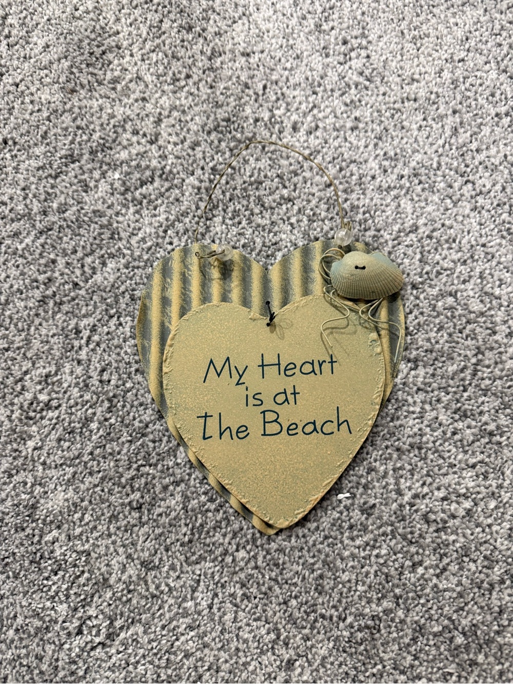 a double layered heart-shaped wooden wall plaque with a corrugated metal accent